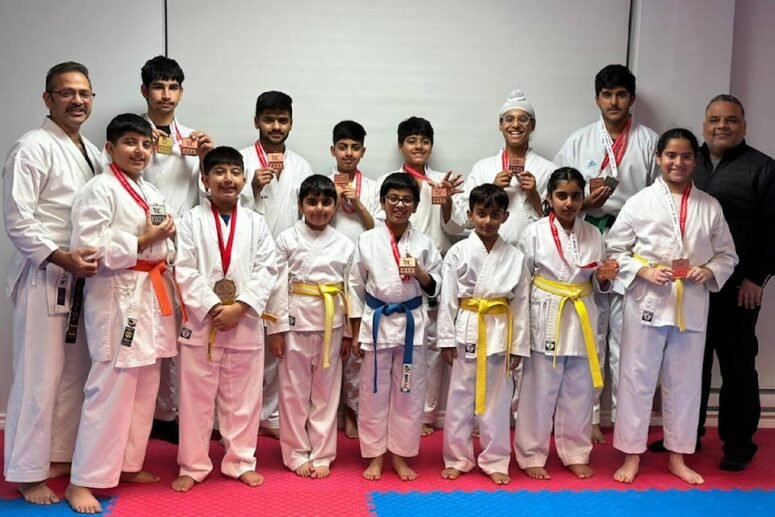 Group photo of students and instructors at Yogi’s Karate Dojo proudly displaying medals earned in a karate competition.