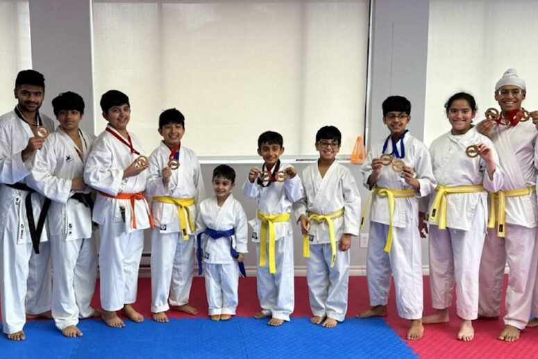 Students from Yogi’s Karate Dojo proudly display their medals after a successful karate competition.